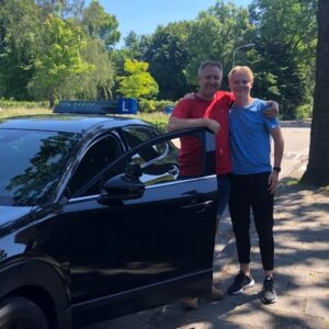 Sander en rij-instructeur-Eric-ten-Barge bij de rijles-auto